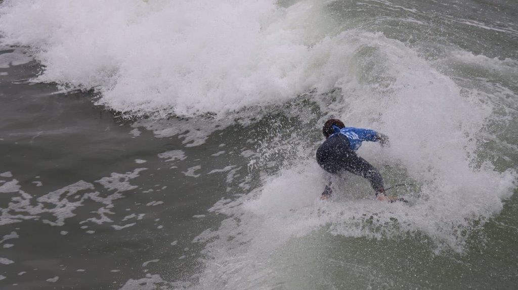 A person surfing in the ocean

Description automatically generated