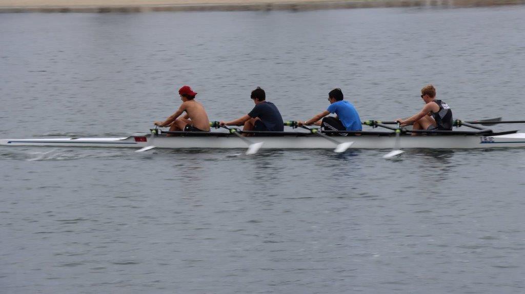 A group of men rowing a boat

Description automatically generated