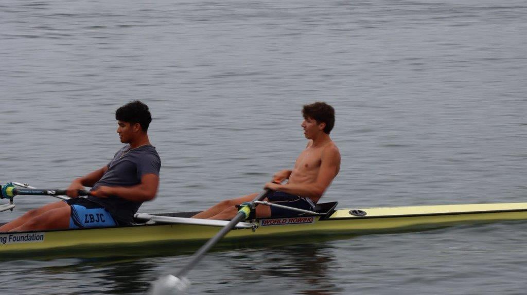 A couple of men rowing a boat

Description automatically generated