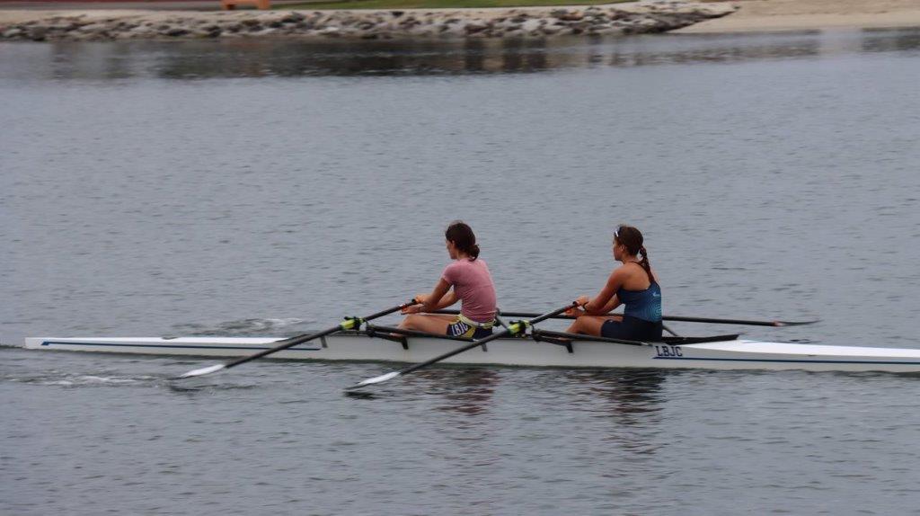 A couple of women rowing a boat

Description automatically generated