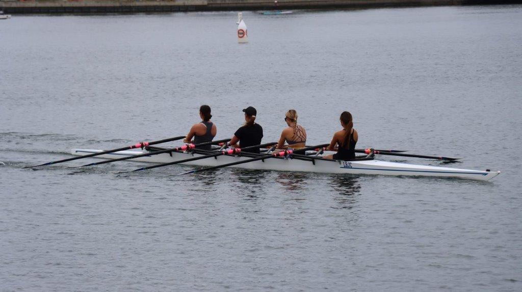 A group of people rowing on a lake

Description automatically generated