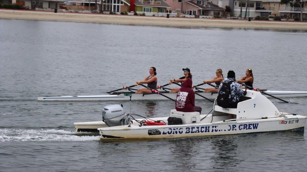 A group of people rowing a boat

Description automatically generated