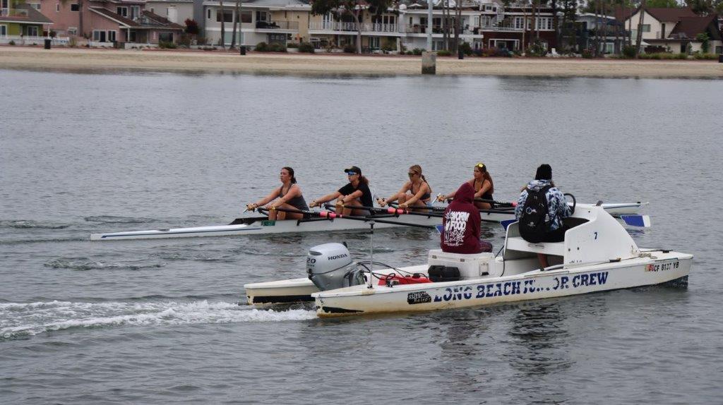 A group of people rowing a boat

Description automatically generated