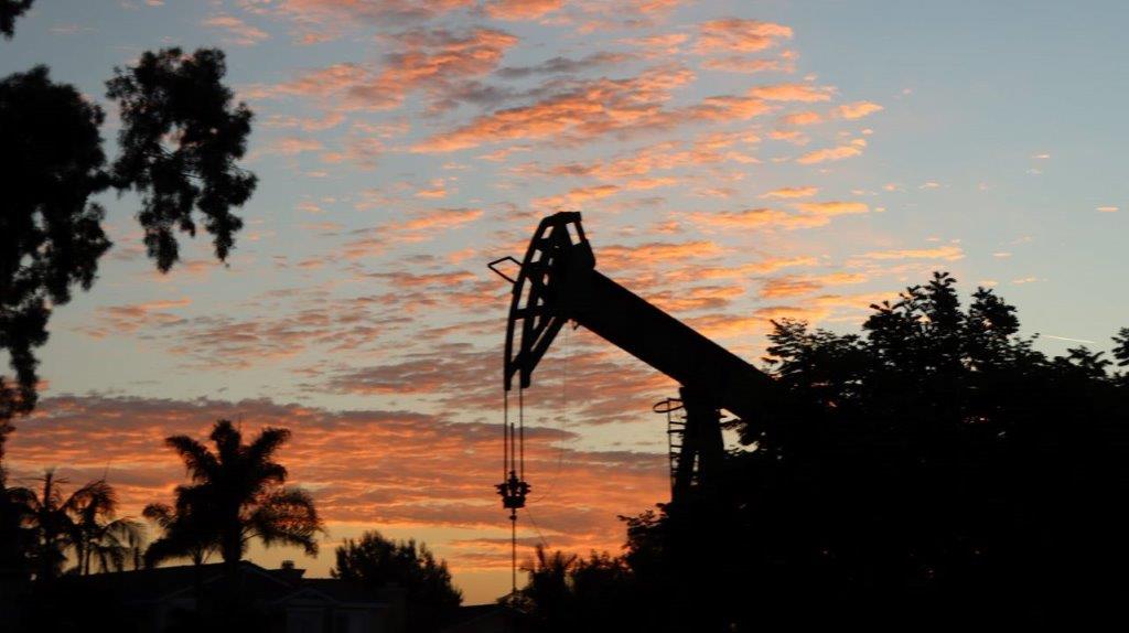 A silhouette of a oil rig

Description automatically generated
