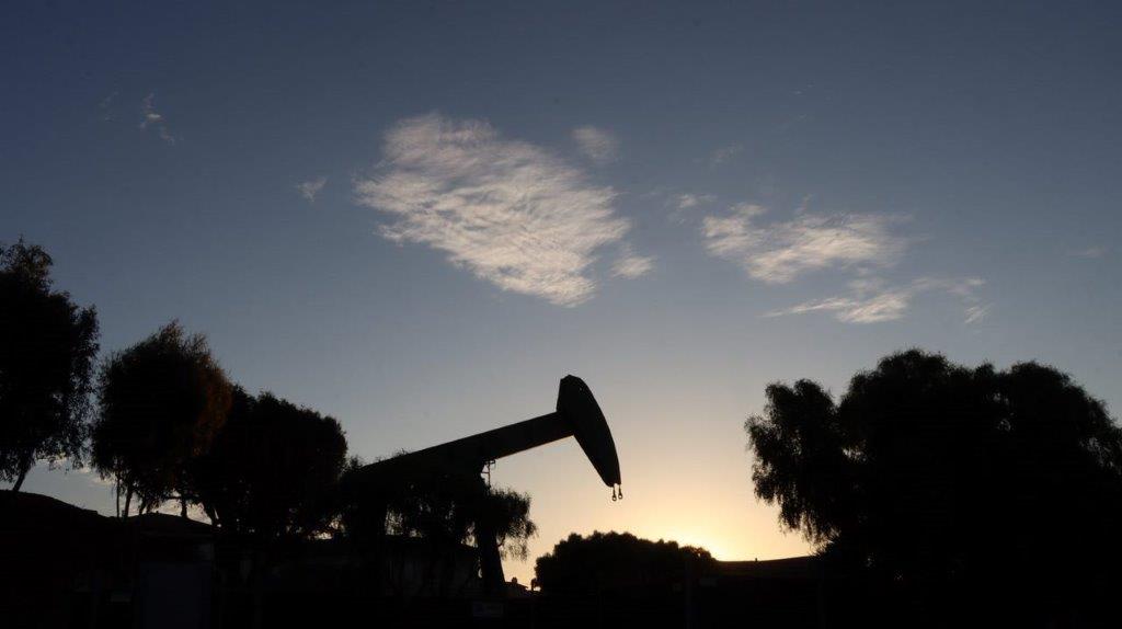 A silhouette of a pumpjack

Description automatically generated