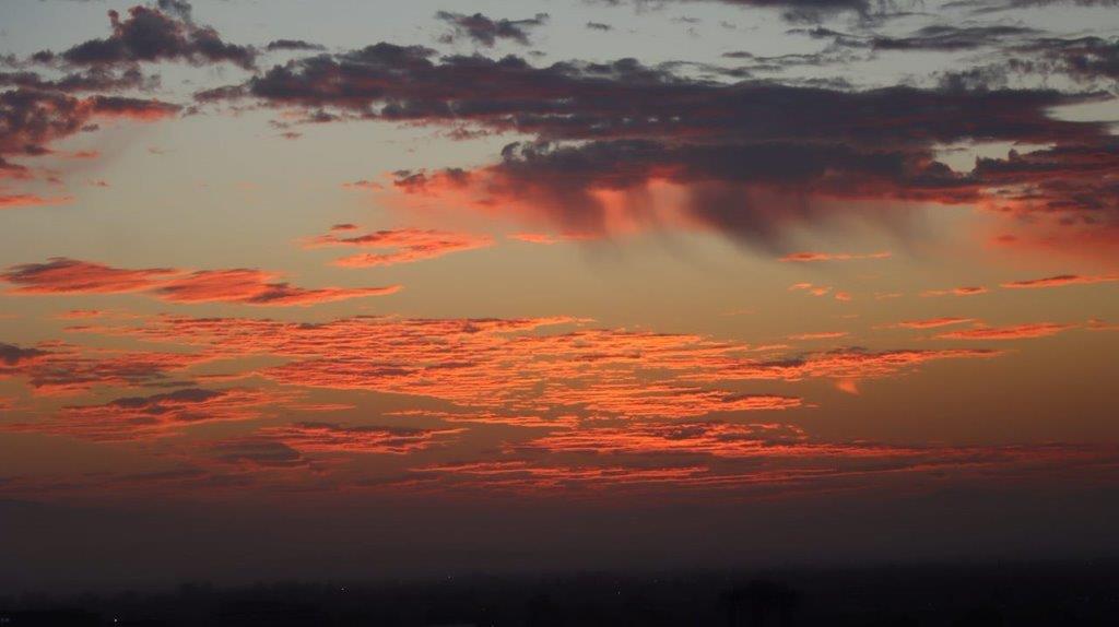 A sunset with clouds in the sky

Description automatically generated