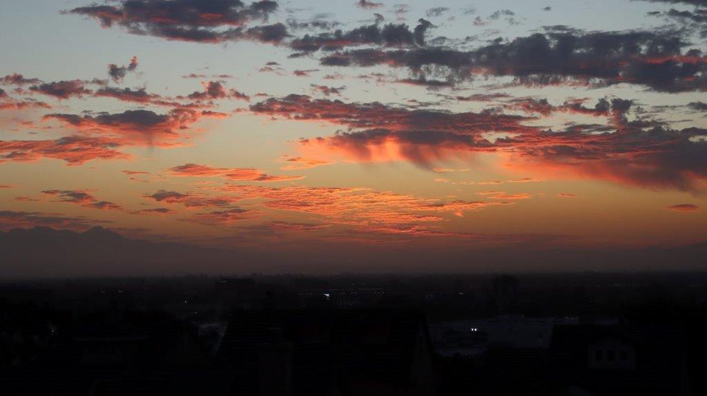 A sunset over a city

Description automatically generated
