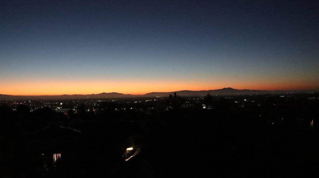 A sunset over a city

Description automatically generated